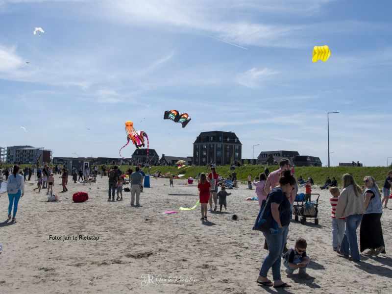 Meerdere vliegers in de lucht en een redelijk vol strand bij het Lanterstrand