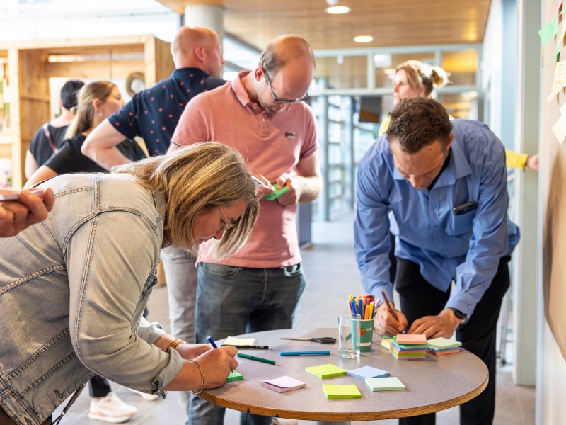 Mensen schrijven ideeën op post its