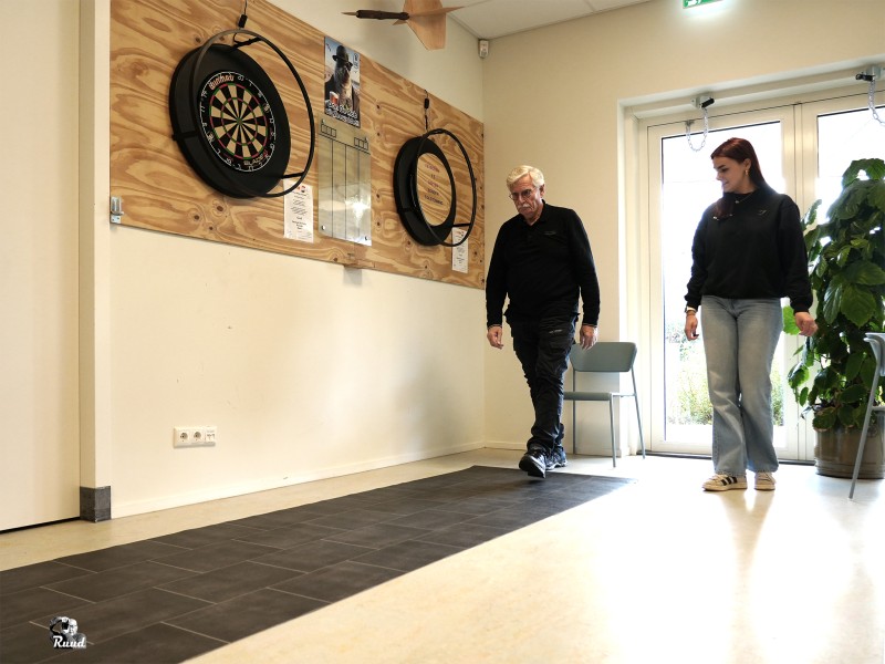 Man loopt over mat met iemand naast zich.