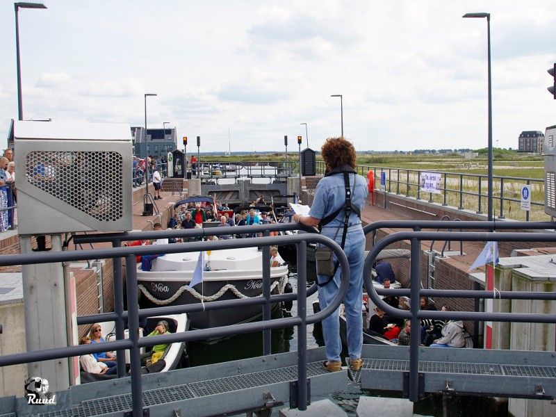 Een verteller bij de sluis die vol ligt met bootjes