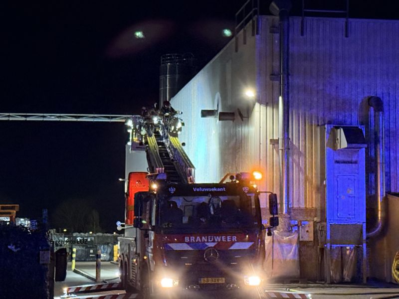 Brandweer mensen in de hoogwerker die de brand blussen