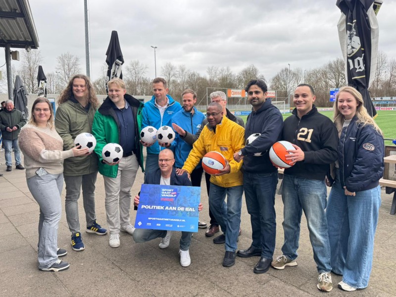 Een serie gemeenteraadsdkinditaten op een rij met een bal, toebedeeld van Ben Scharft