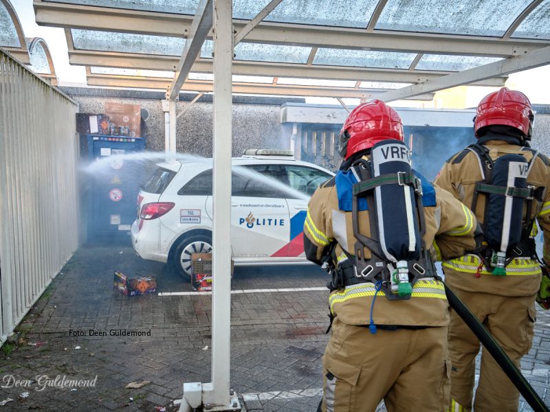 2 brandweermannen die voor de oefening bij een politieauto blussen