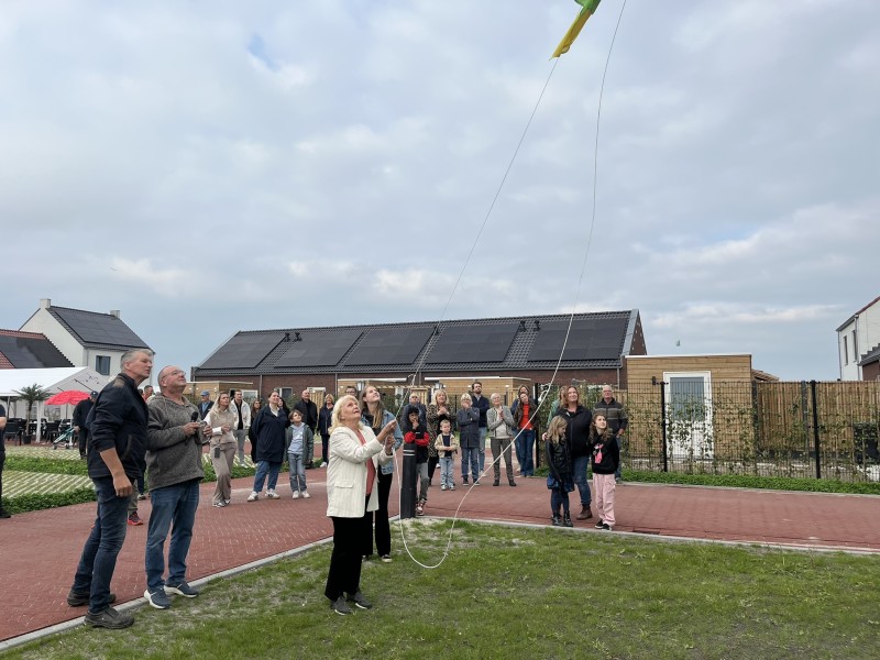 Twee mensen hijsen een vlag.