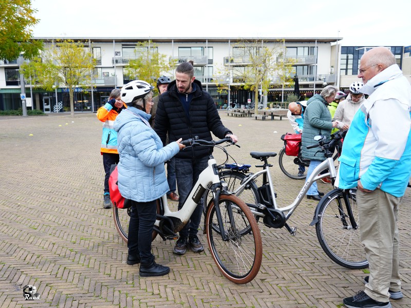 Oudere mensen op de fiets met iemand die instructie geeft.