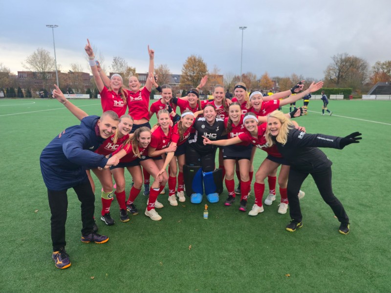 Hockeyteam dames staan naast elkaar op de foto op hockeyveld.
