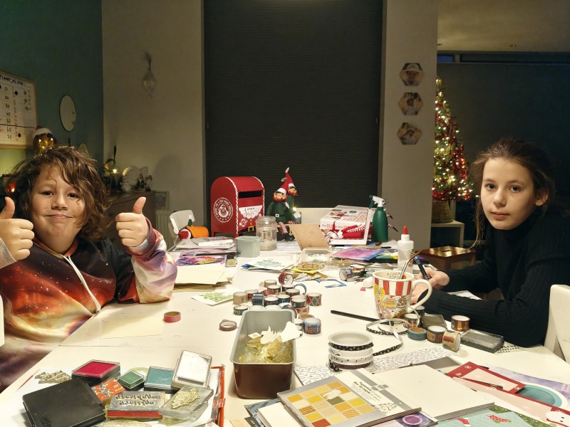 Twee kinderen zitten aan tafel te knutselen.