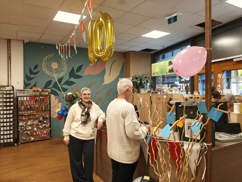 Foto in een winkel met een grote gouden tien boven mevrouw
