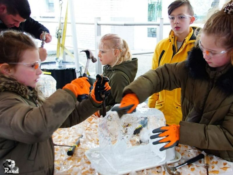 Jongeren vermaken zich met het maken van ijssculpturen