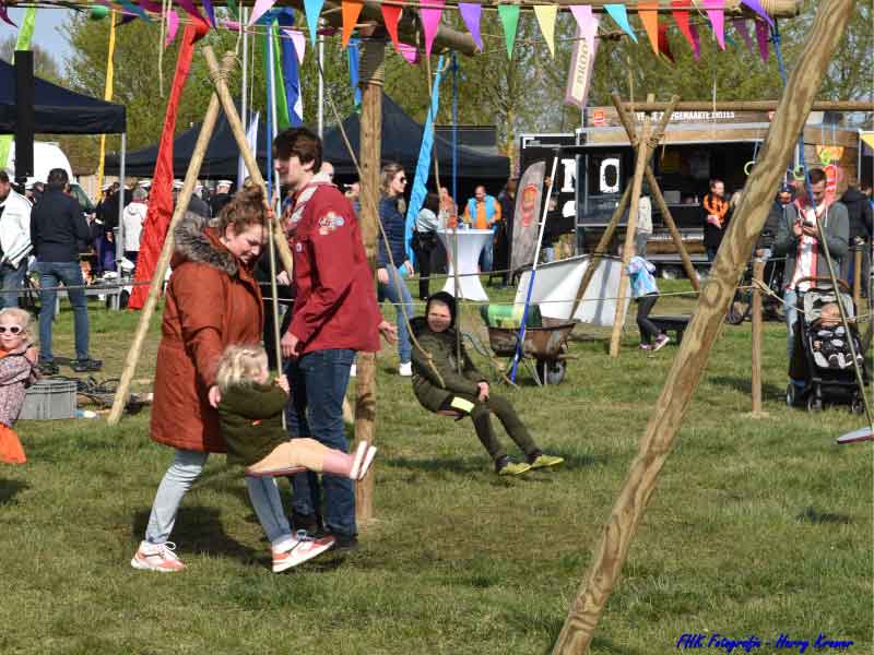 Kinderen in de gemaakte draaimolen van de scouting op het evenemententerrein