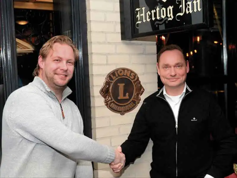Tim van Oosten en Jeroen Brakke schudden elkaar de hand bij het Lionsschild