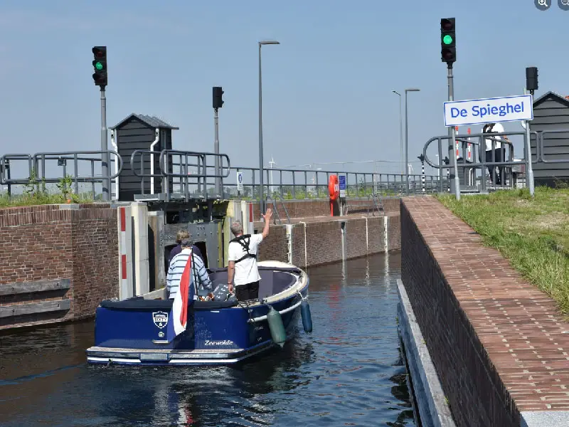 Boot die de sluis de spieghel in vaart om te schutten