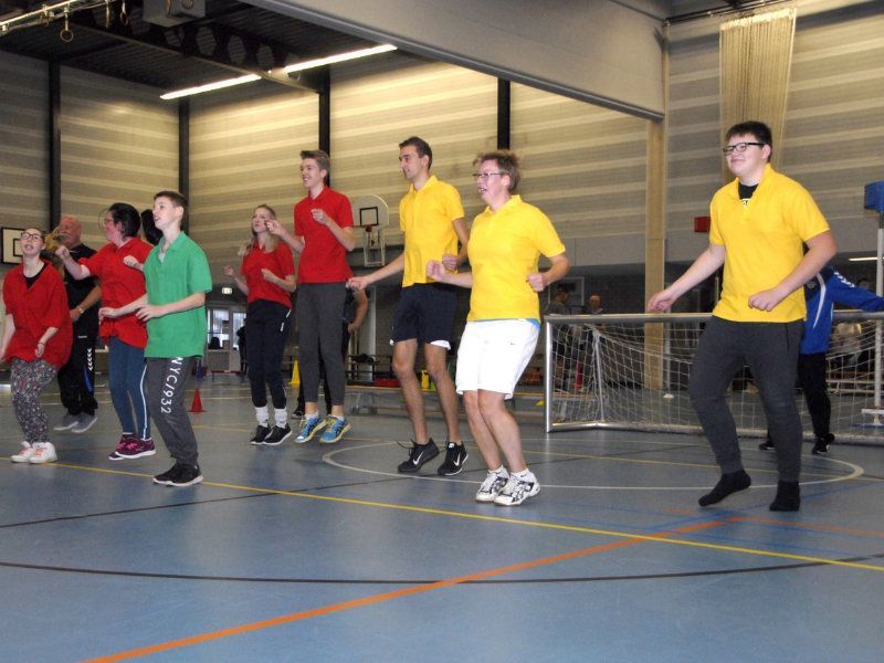 een groep mensen die aan het springen zijn in een sporthal , ze hebben plezier