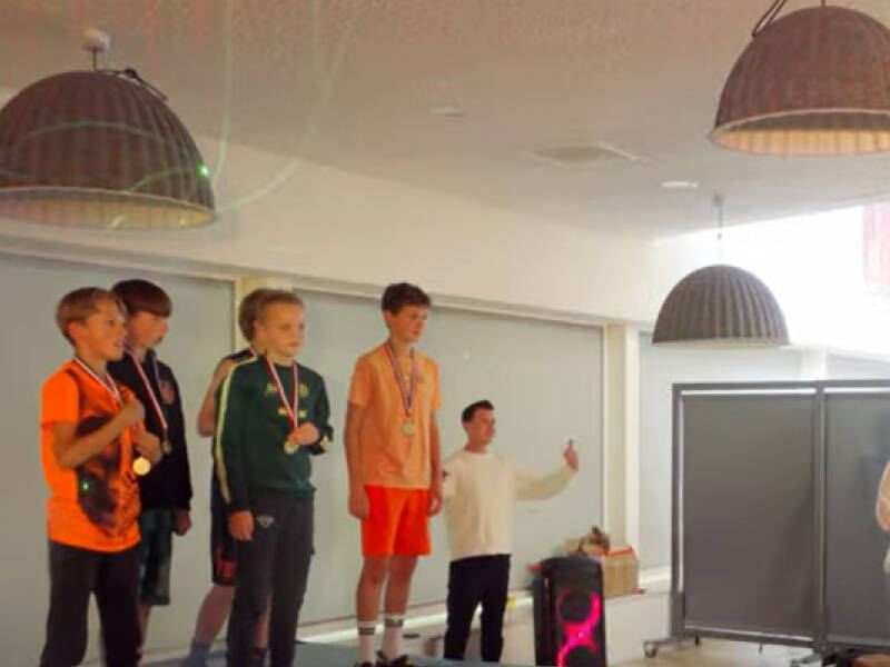 Een jeugd bastketbal teams op een "podium" met medailles om