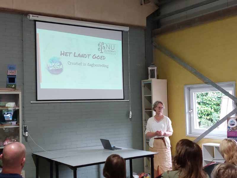 Jolanda voor het scherm met de presentatie in een zaaltje bij nu jij werkt