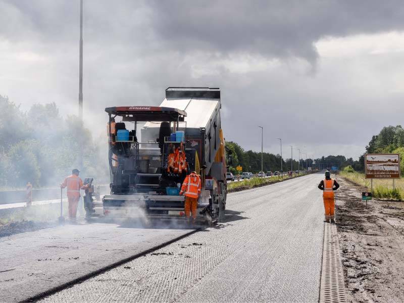 Wegwerkers met asfalteermachine op de ganzenweg