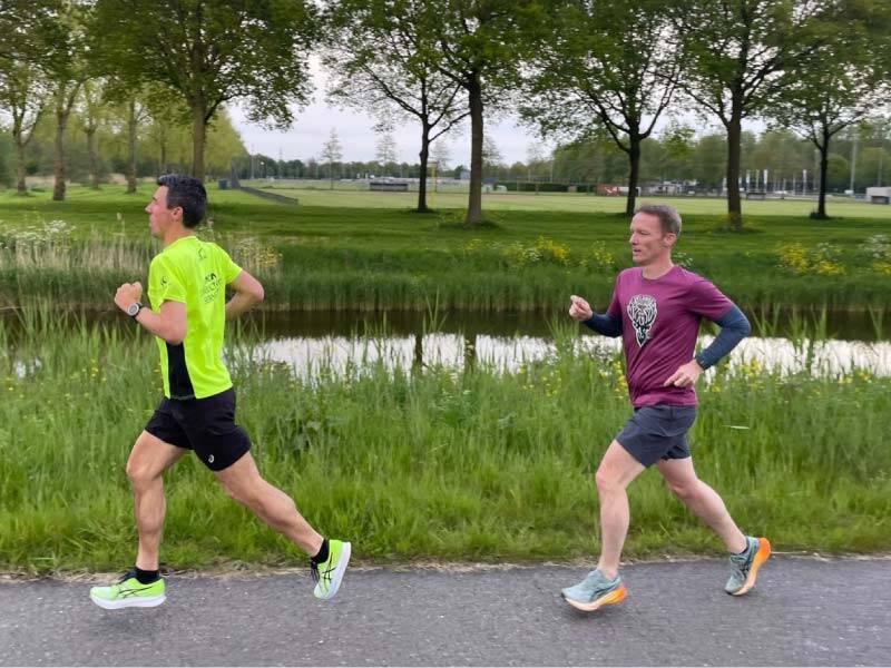 2 hardlopers langs een fietspad en een vaart