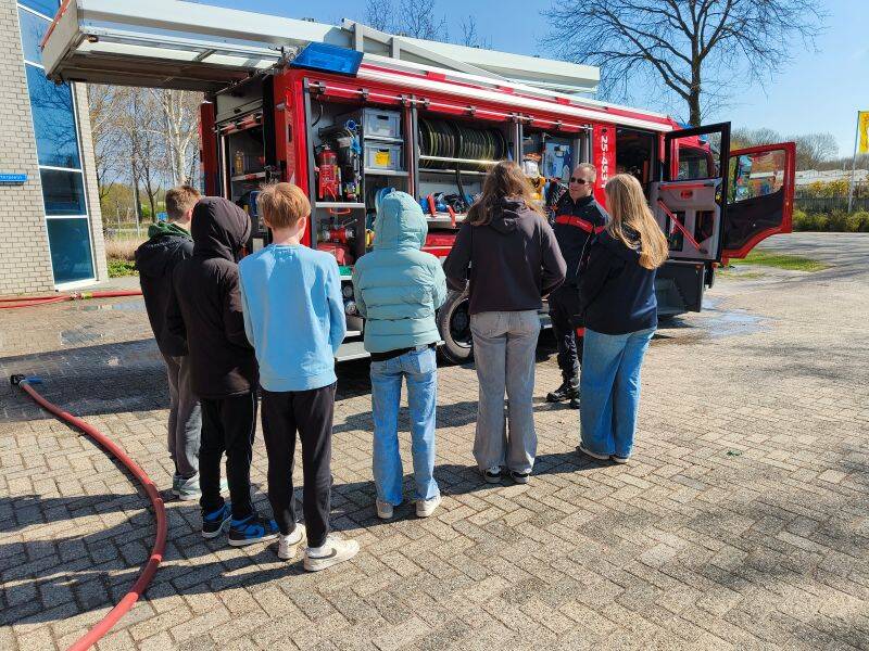 groepje mensen voor brandweerauto
