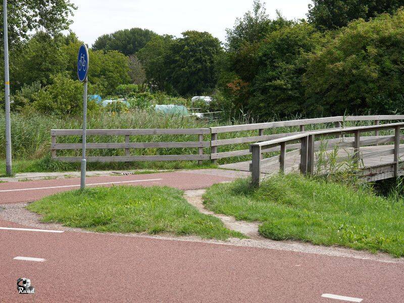 Foto van een afsnijroute met een paadje langs het originele pad.