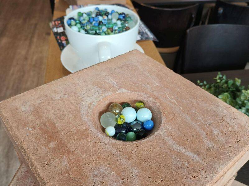 foto van een knikkertegel met knikkers eromheen