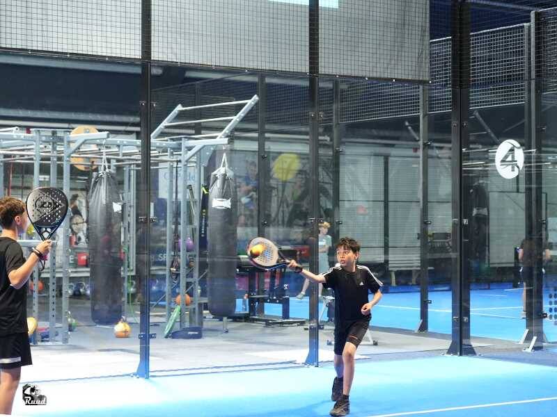 Kinderen op een padelveld druk aan het spelen