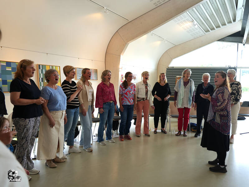Groep mensen die samen zingen in lichte ruimte