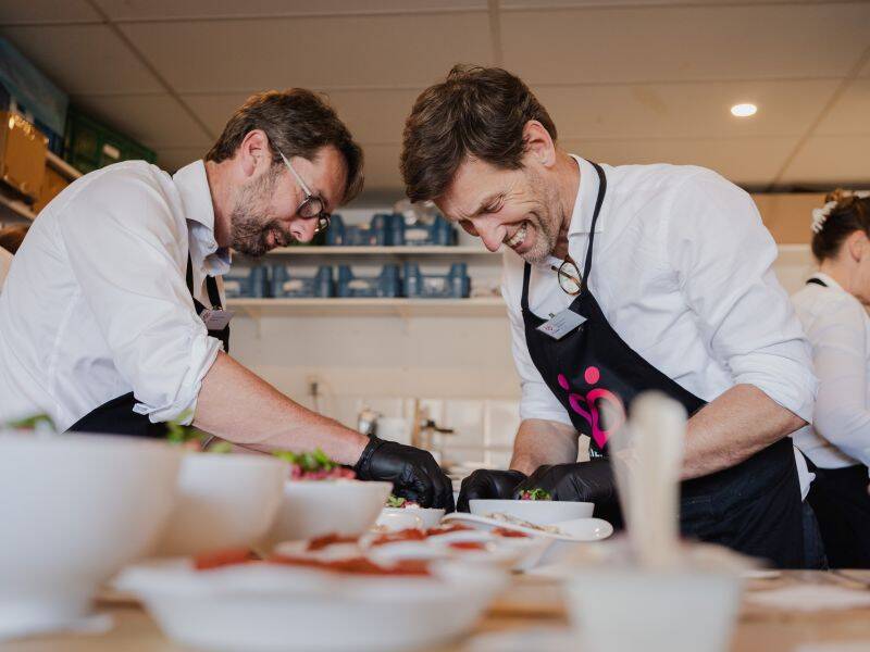 twee kokende mannen met witte blouse en koksschort