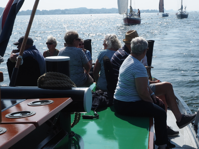 mensen zitten op een schip die vaart op het water