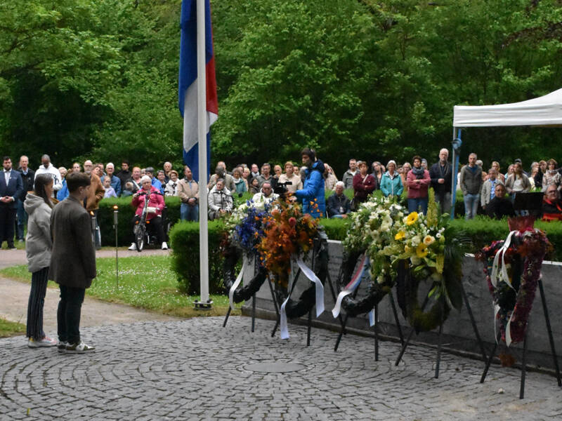 2 kinderen die een krans hebben gelegd bij het monument op de begraafplaats in Zeewolde