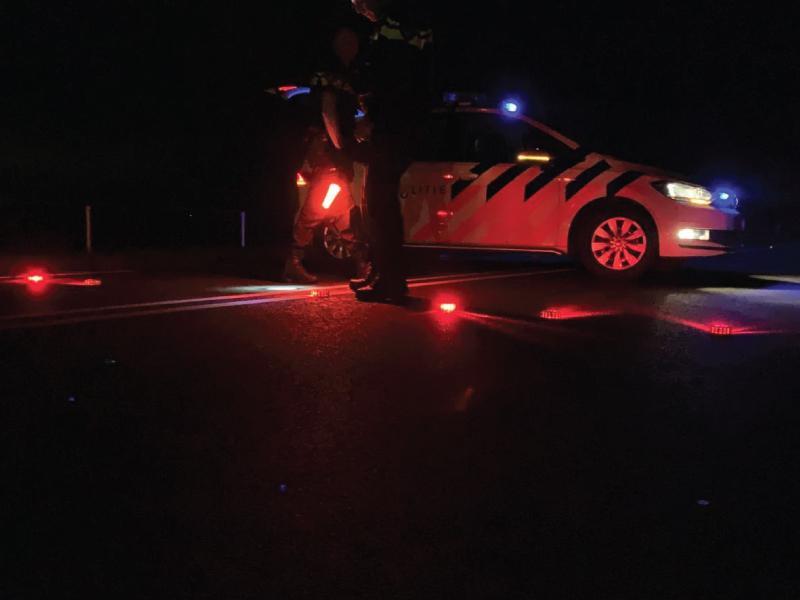 Wegafzetting van politiewagen met lampjes in het donker